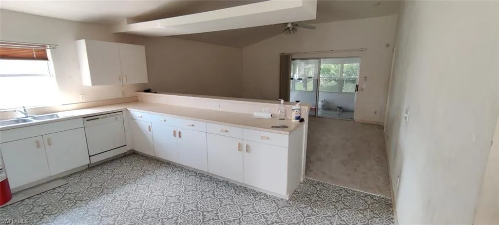 Kitchen featuring dishwasher, plenty of natural light, white cabinetry, and sink