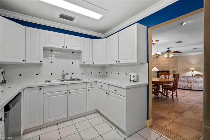 Kitchen with ornamental molding, sink, dishwasher, and backsplash