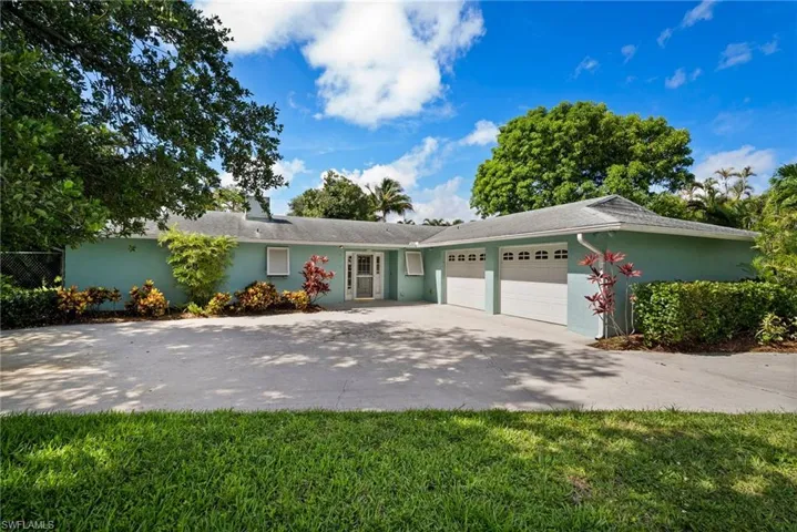 Ranch-style home featuring a garage and a front yard