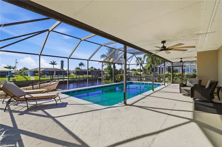 Outdoor pool featuring a lanai, a sunroom, a patio area, a water view, and a residential view