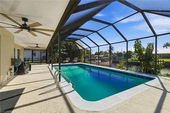 Outdoor pool with a sunroom, a lanai, a patio, and a water view