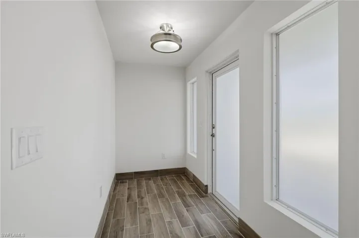 Hallway with wood tiled floors and baseboards