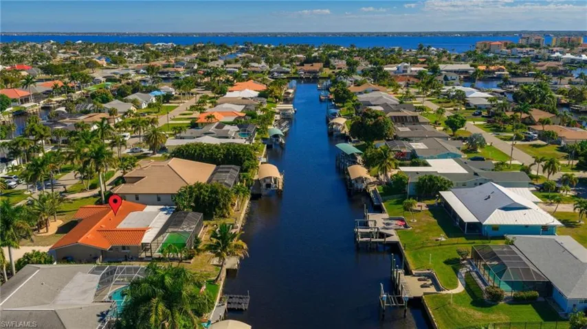 Aerial view of property's location with a nearby body of water and nearby suburban area