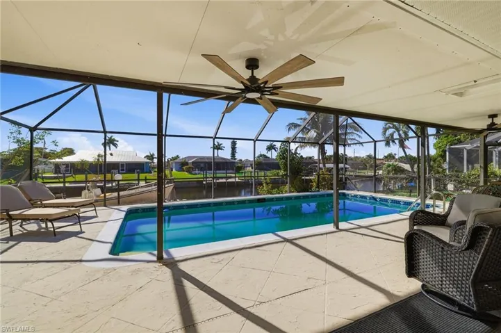 Swimming pool featuring a lanai, a sunroom, a patio, and a water view