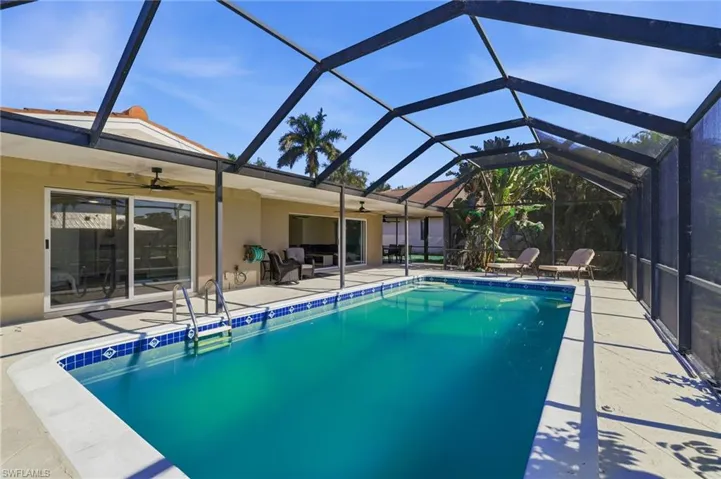 Outdoor pool featuring a sunroom, a lanai, and a patio
