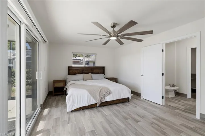 Bedroom with wood finish floors, access to exterior, and a ceiling fan