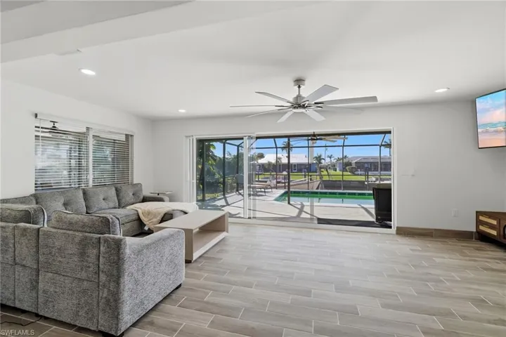 Living room featuring wood tiled floors, a sunroom, plenty of natural light, recessed lighting, and ceiling fan