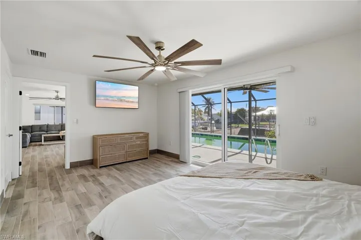 Bedroom featuring access to exterior, light wood finished floors, and ceiling fan