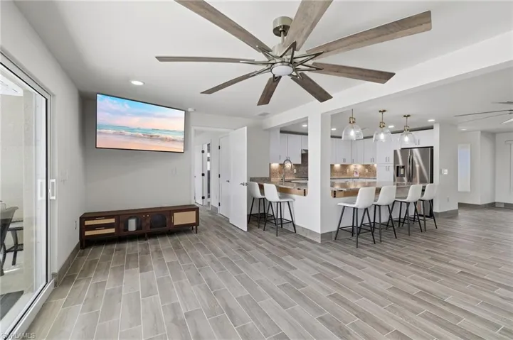Living room featuring ceiling fan, wood tiled floors, and recessed lighting