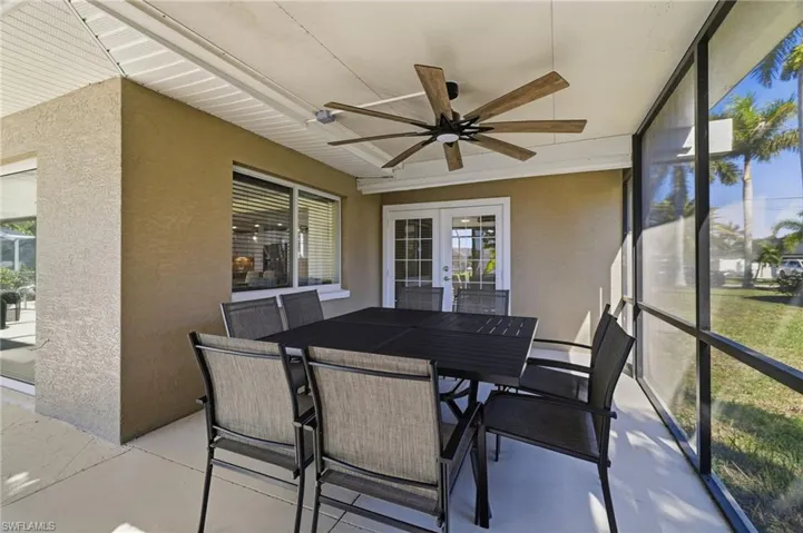 Sunroom featuring outdoor dining area, a ceiling fan, and french doors