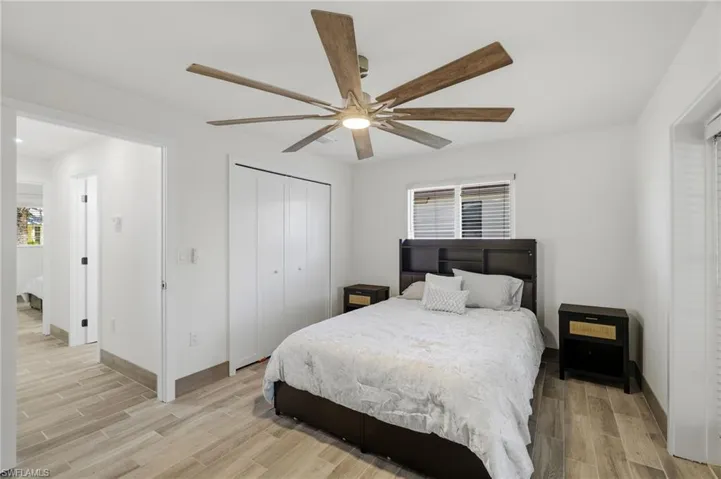 Bedroom with wood finish floors, a closet, and ceiling fan