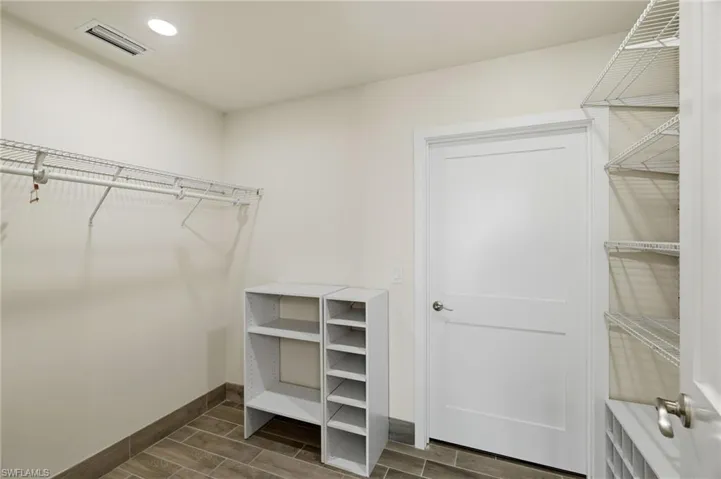 Walk in closet featuring wood finish floors