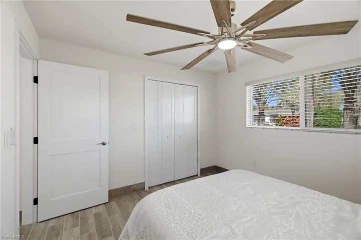 Bedroom with wood finish floors, ceiling fan, and a closet