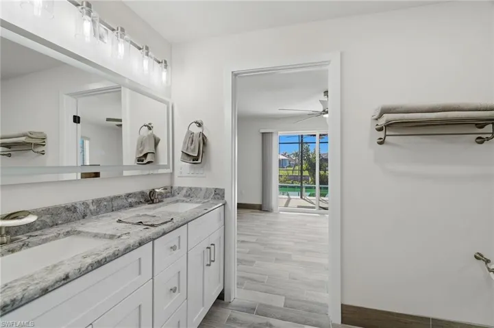 Bathroom with double vanity, wood finish floors, and a ceiling fan