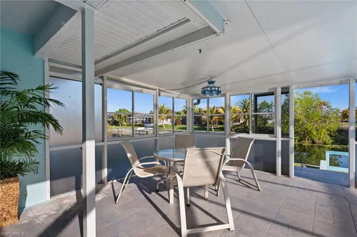 Sunroom featuring stone tile flooring and a water view