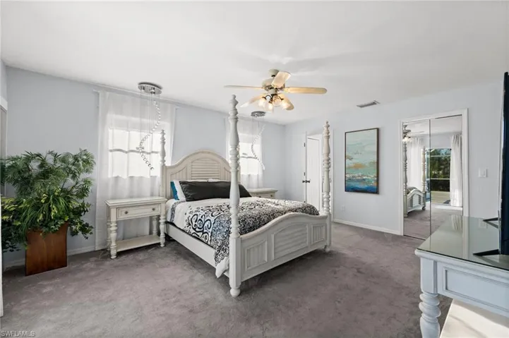 Bedroom with carpet, multiple windows, and ceiling fan