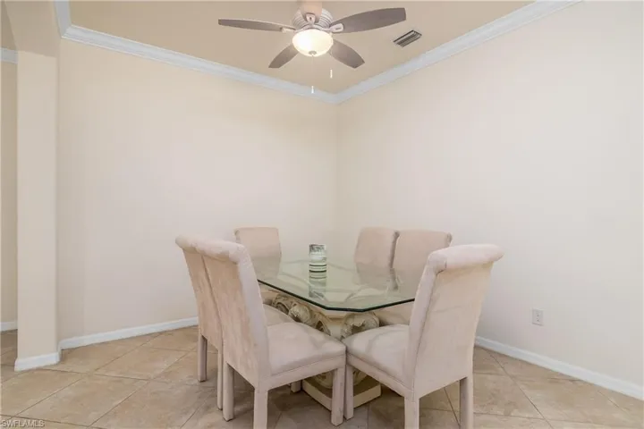 Dining room featuring ornamental molding, light tile flooring, and ceiling fan