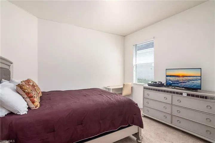 Bedroom featuring light colored carpet
