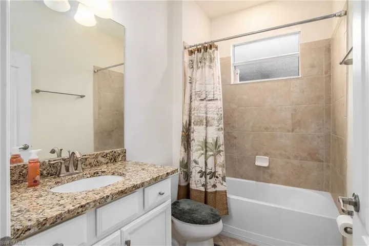 Full bathroom featuring shower / bath combo, toilet, and large vanity