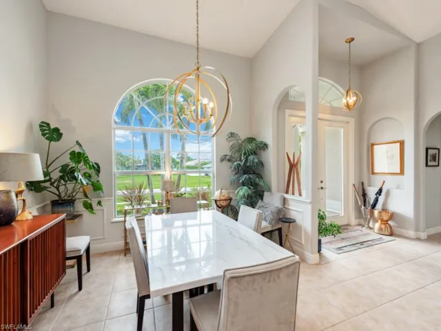 Tiled dining space with high vaulted ceiling and a chandelier