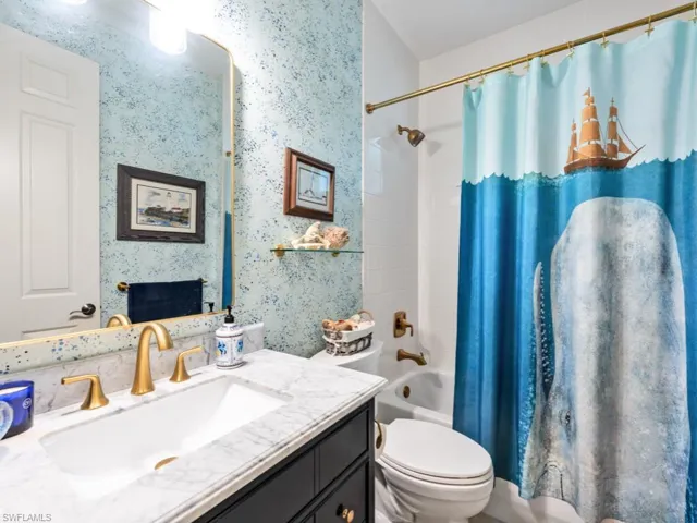 Full bathroom featuring shower / bathtub combination with curtain, vanity, and toilet