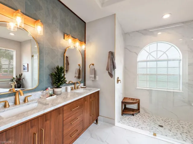 Bathroom with double vanity, tile walls, a healthy amount of sunlight, and tile patterned flooring