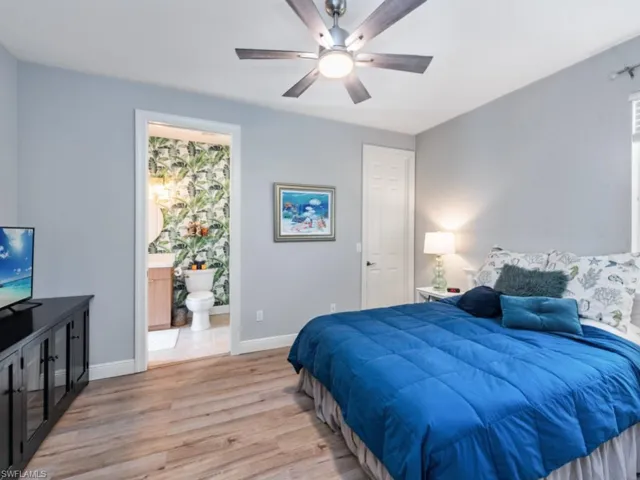 Bedroom featuring connected bathroom, ceiling fan, and light wood-type flooring