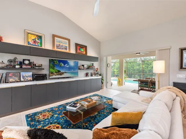 Tiled living room featuring vaulted ceiling