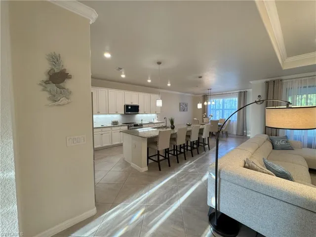 Living area featuring ornamental molding and light tile patterned floors
