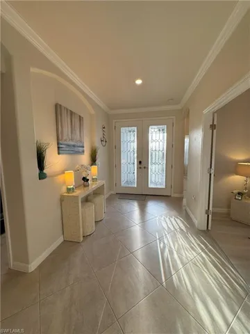 Doorway to outside featuring french doors, arched walkways, crown molding, and recessed lighting