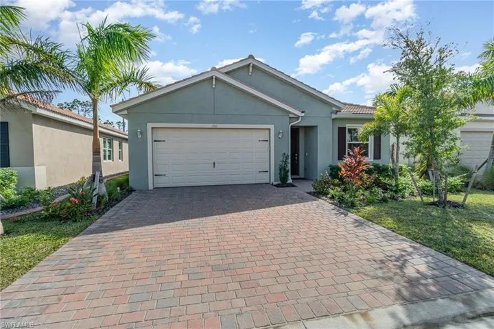 View of front of property featuring a front yard and a garage