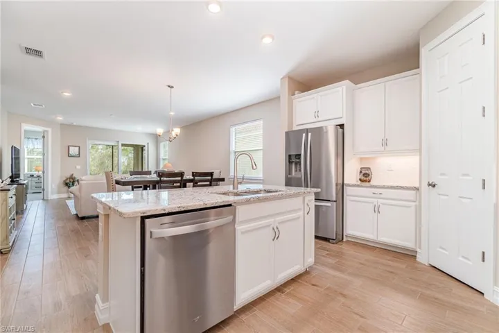 Kitchen featuring white cabinetry, a kitchen island with sink, stainless steel appliances, and sink