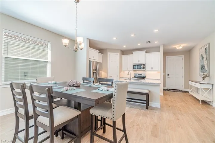 Dining space with light hardwood / wood-style floors, an inviting chandelier, and sink