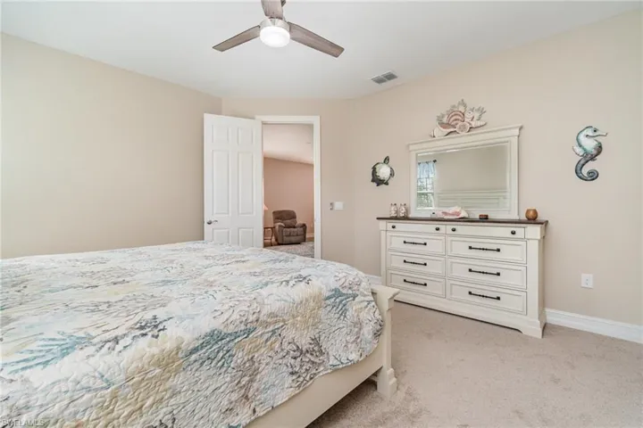 Carpeted bedroom featuring ceiling fan
