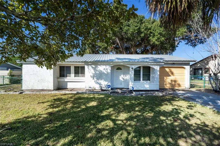 Ranch-style house featuring a metal roof, stucco siding, driveway, and an attached garage