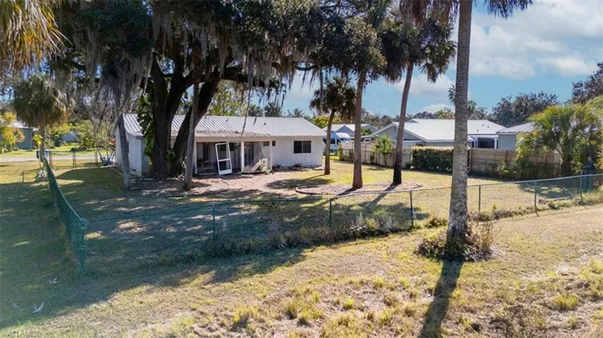 View of front of property with a fenced backyard and a metal roof