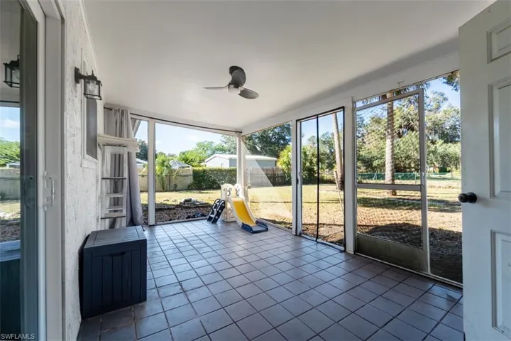 Unfurnished sunroom featuring plenty of natural light and ceiling fan