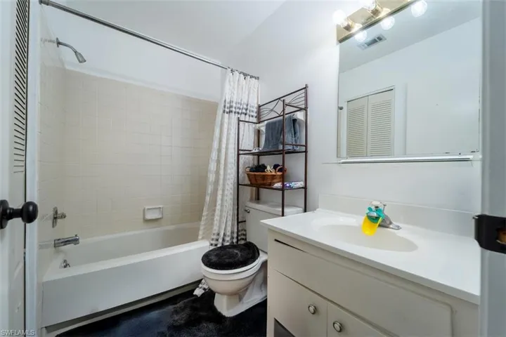 Full bathroom with vanity, shower / tub combo, and a closet