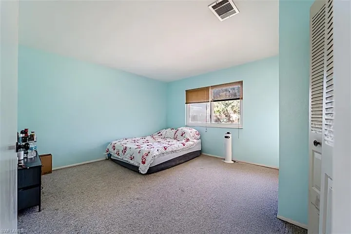 Carpeted bedroom featuring baseboards and a closet