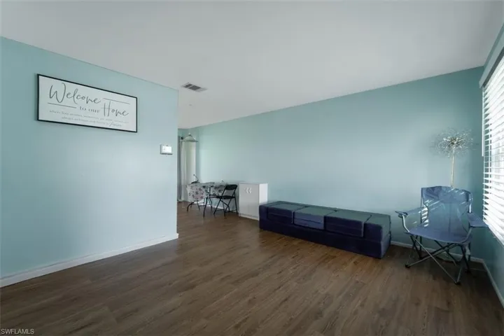 Unfurnished room featuring dark wood-style flooring and baseboards