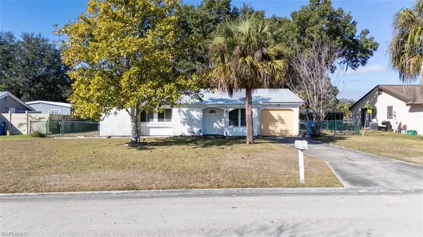 Ranch-style house with driveway and stucco siding