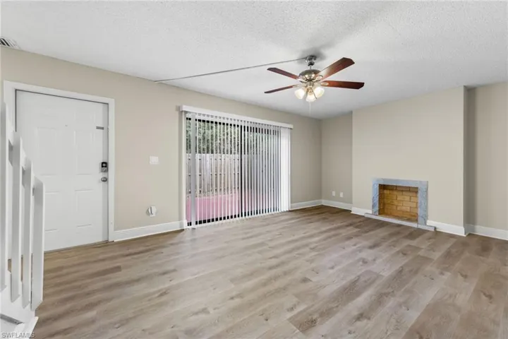 Unfurnished living room with a textured ceiling, ceiling fan, and light wood-type flooring