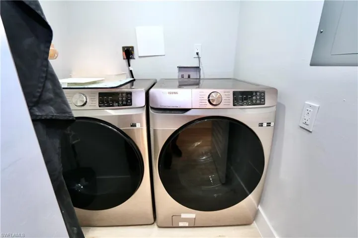 Clothes washing area with separate washer and dryer, laundry area, and electric panel