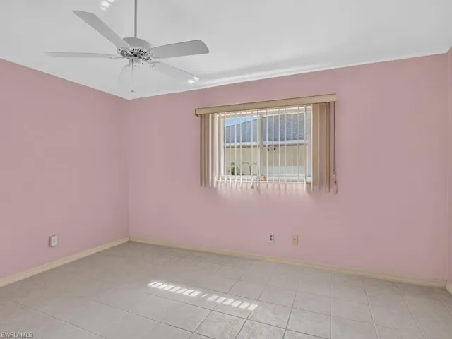 Square tile flooring, window with vertical blinds, ceiling fan with light kit, and crown molding