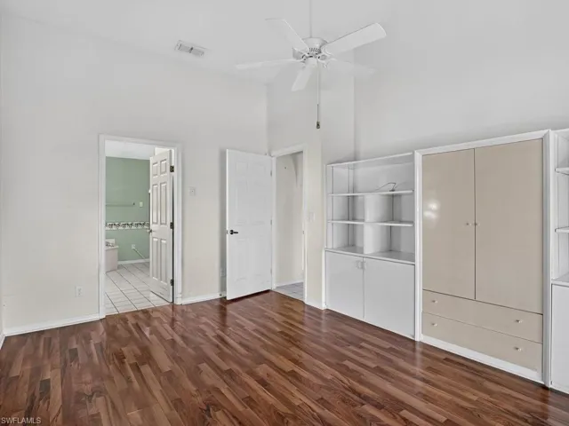 Wood-finish flooring, built-in cabinetry, and a ceiling fan