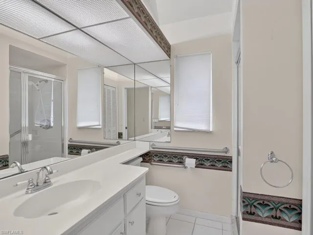 White vanity with an integrated sink, chrome faucet, and mirrored wall