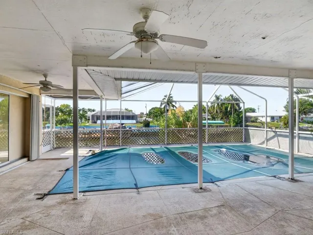 Screened outdoor living area featuring multiple ceiling fans, a covered pool area, and direct water frontage