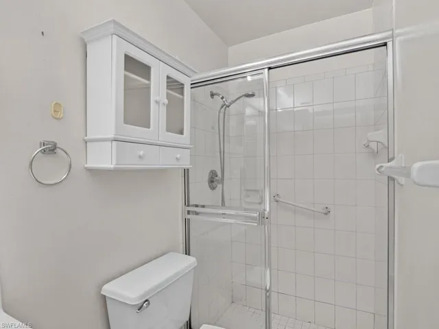 White tiled shower with glass enclosure and chrome hardware