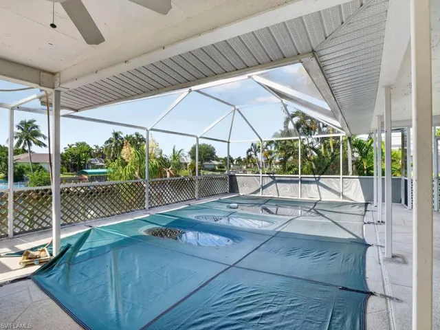 Screened-in patio with a covered pool, water frontage, and a ceiling fan
