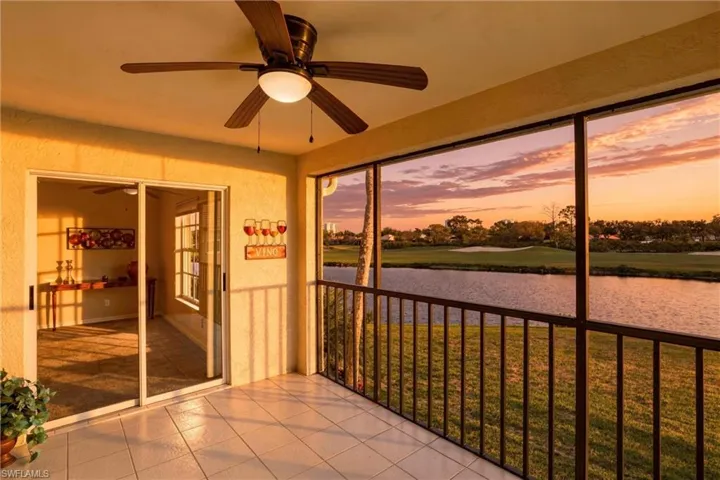 Unfurnished sunroom featuring a water view, ceiling fan, and golf course view